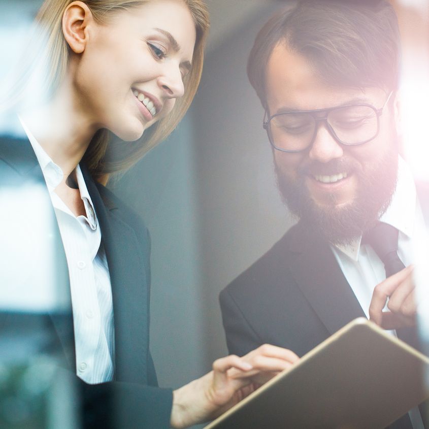 To menn snakker sammen ved glassvegg